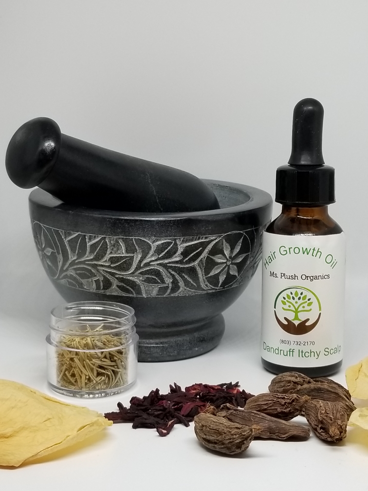 A stone mortar and pestle, dried herbs and a bottle of Ms. Plush Organics growth oil