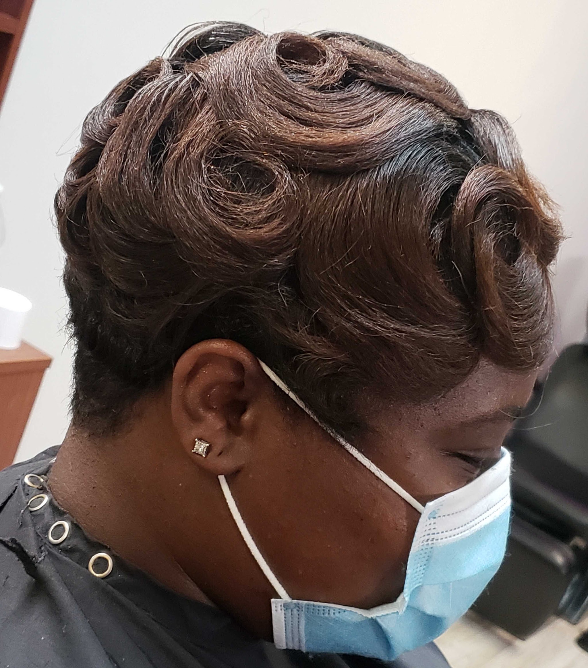 A short sculpted pin-curl style in warm brown tones